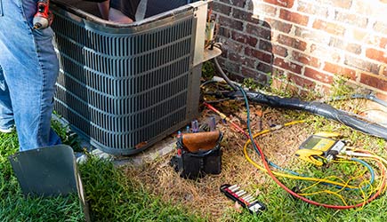 Technician repairing AC outdoor unit