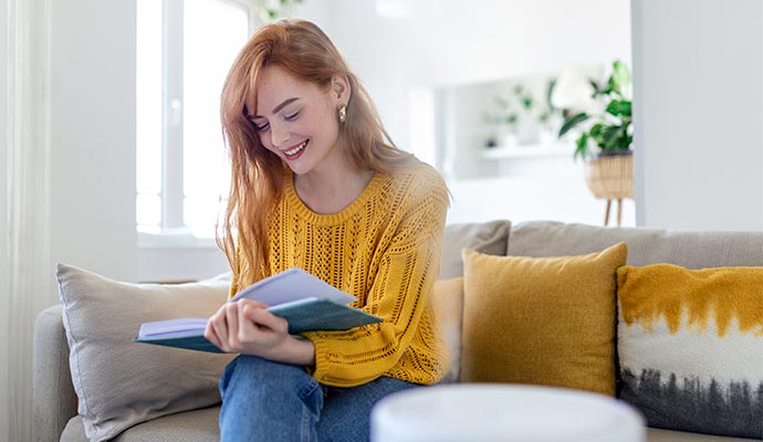 Woman reading a book in a living room with balanced humidity for a comfortable environment