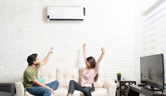 Couple sitting on couch under the AC system